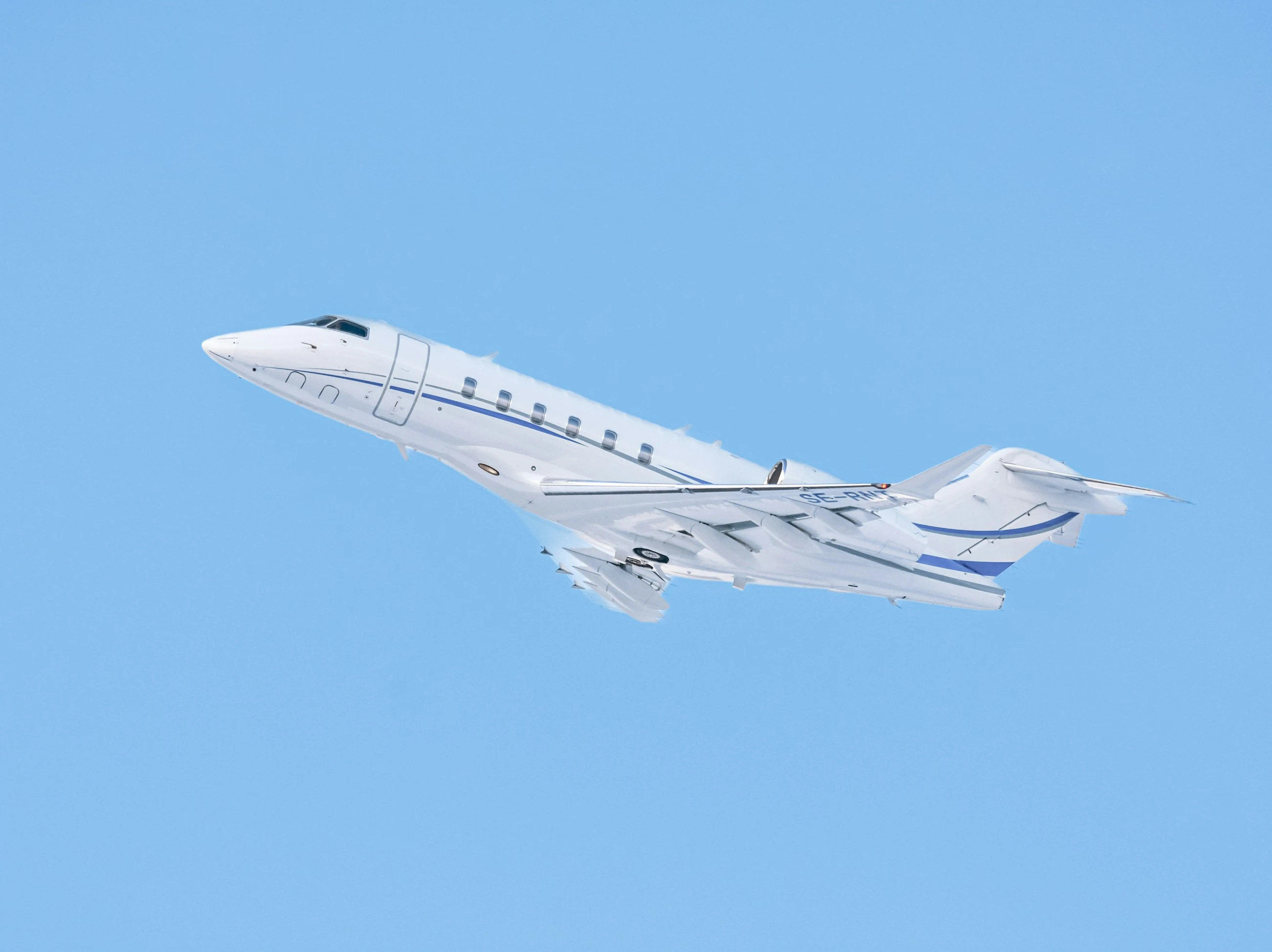 Jet ejecutivo blanco en vuelo, con alas y cola visibles